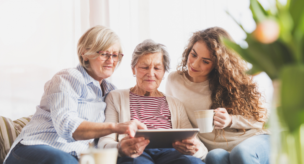 Three women looking at a tablet or ipad.